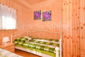 a bedroom with a bed and two pictures on the wall at Domki Bahama in Bobolin