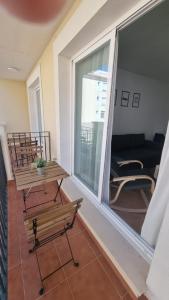 a balcony with benches and a view of a living room at Moderno Apartamento 3 dormitorios, garaje y piscina in La Algaba