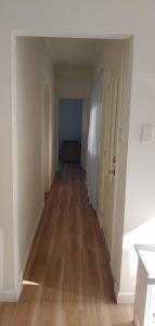 an empty hallway of an apartment with a hard wood floor at Great Three Bedroom House Opposite Hospital & University in Frankston