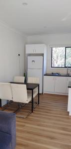 a living room with a table and a kitchen at Great Three Bedroom House Opposite Hospital & University in Frankston