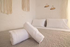 een wit bed met 2 kussens erop bij Beachfront Lovely Small House on the Sea in Paránimfoi