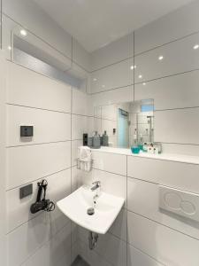 a white bathroom with a sink and a mirror at Modern und Gemütlich Augsburg Center Kongress in Augsburg