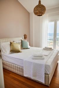 um quarto branco com uma cama grande e um lustre em Athens Riviera Villa em Anavissos