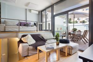 a living room with a couch and a table at Barcino Inversions - Bright Apartment in Gracia with shared Pool in Barcelona