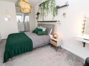 1 dormitorio con 1 cama con manta verde en 20 Bishops Way, en Falmouth