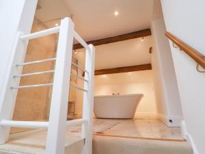 a staircase leading up to a bathroom with a bath tub at Bride Cross Granary in Otley