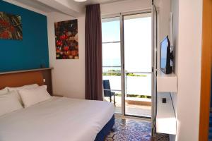 Habitación de hotel con cama y puerta corredera de cristal en Hotel Monaco & Garden, en Golem