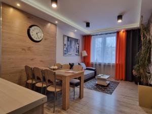 a dining room with a table and a clock on a wall at Zachodnia - 3 Pokoje, Parking, , FV in Łódź