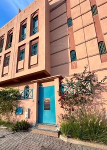 un edificio con una puerta azul delante de él en Spacious 3-Floor Riad en Marrakech