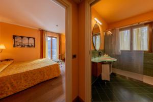 una camera con letto e un bagno con lavandino di La Darsena Boutique Hotel & Restaurant a Tremezzo