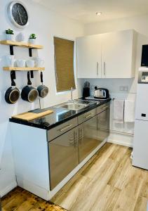 una cocina con armarios blancos y fregadero en The Summer House - Free Onsite Parking, en Cambridge