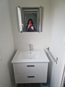 a person taking a picture of a sink in a bathroom at A La Rencontre Du Soleil - Camping in Le Bourg-dʼOisans