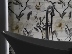 a bathroom sink with a floral shower curtain at The Mount in Bideford
