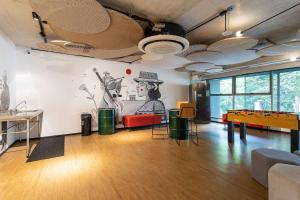 ein Raum mit einer Tischtennisplatte und einem Wandgemälde in der Unterkunft Caza Noz by Viva - Apartamentos com ótima estrutura e área comum próximo à USP e Butantã in São Paulo