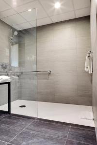 a shower with a glass door in a bathroom at Hôtel Rallye & Entrées aux Bains de la Gruyère in Bulle