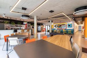 eine Cafeteria mit Tischen und Stühlen und einem Foodtruck in der Unterkunft Caza Noz by Viva - Apartamentos com ótima estrutura e área comum próximo à USP e Butantã in São Paulo