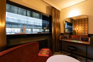 bagno con finestra, specchio e lavandino di The Home Hotel Zürich - a member of DESIGN HOTELS a Zurigo