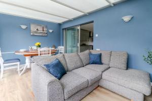 uma sala de estar com um sofá cinzento com almofadas azuis em Tiger House Stevenage 5 Bed 4 Bath Group Bookings em Stevenage