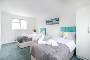 um quarto com duas camas com cisnes em Tiger House Stevenage 5 Bed 4 Bath Group Bookings em Stevenage