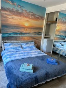 two beds in a bedroom with a beach mural at Lily Bank Room in Stonehaven