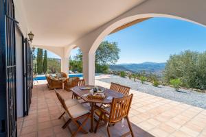 a patio with a table and chairs and a view at Casa Hyam in Alcaucín