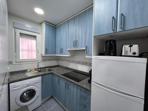 cocina con armarios azules y nevera blanca en Cosy flat Arganzuela - AC en Madrid