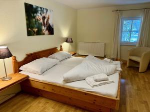 una camera da letto con un grande letto con lenzuola bianche di Familienfreundliche Ferienwohnung im schönen Thierseetal, FeWo 16 a Thiersee