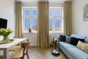 a living room with a blue couch and a table at Elite Apartments Kamienice Old Town in Gdańsk
