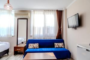 een woonkamer met een blauwe bank en een bed bij City Hall Apart Hotel in Istanbul