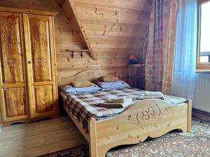 una camera da letto con letto in una camera in legno di Zakątek w Dolinie a Łapszanka