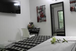 Habitación con mesa y suelo a cuadros en blanco y negro. en La Cabrera Hotel Boutique, en Neiva