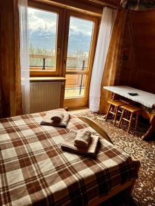 a bedroom with a bed with towels and a window at Zakątek w Dolinie in Łapszanka