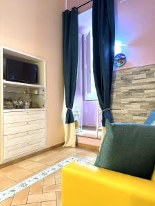 uma sala de estar com um sofá amarelo e uma televisão em Casa Tonia San Cesareo em Sorrento