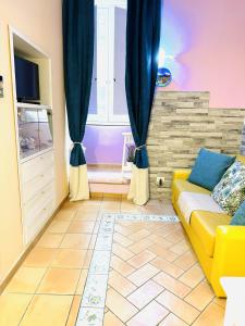 uma sala de estar com um sofá amarelo e uma janela em Casa Tonia San Cesareo em Sorrento