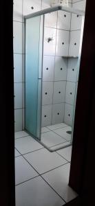 a bathroom with a shower with a mirror at Pousada Parada Da Fé in Aparecida
