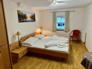 1 dormitorio con 1 cama, 1 silla y 1 ventana en Familienparadies MoNi Ferienwohnung 17, en Thiersee