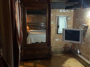 una camera da letto con comò e televisore di Casa rural en Redes a Ríoseco