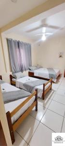 a group of three beds in a room at Pousada Parada Da Fé in Aparecida