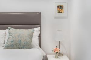 a bedroom with a bed with a pillow and a lamp at Livestay Stunning 2 bed apartments in Stratford in London