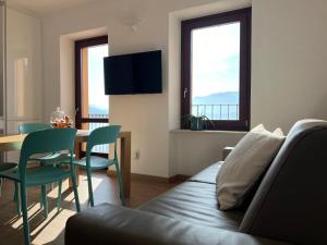 ein Wohnzimmer mit einem Sofa und einem Tisch mit Stühlen in der Unterkunft Al Porticciolo - Casa Vacanze in Marone