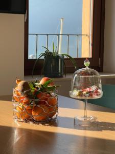 eine Schale Obst auf einem Tisch neben einem Glas-Gericht in der Unterkunft Al Porticciolo - Casa Vacanze in Marone