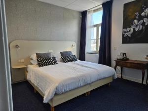 um quarto com uma cama com almofadas e uma janela em Hotel 1711 em Valkenburg