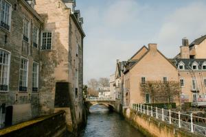 a river in a city with buildings and a bridge at Hotel 1711 in Valkenburg