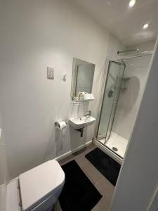 y baño blanco con aseo y ducha. en Central London Gem 1 BR Flat Piccadilly Circus VR8, en Londres