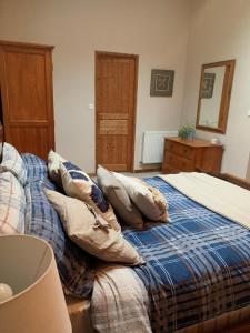 um quarto com uma cama com almofadas em Les Guittieres Gites em Sarcé