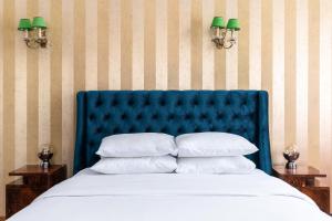 un lit avec une tête de lit bleue et 2 tables de chevet dans l'établissement #Figaro apt by halu!, à Thessalonique
