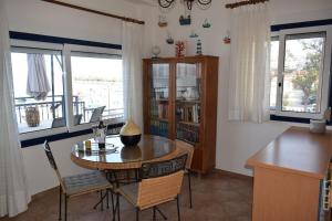 comedor con mesa, sillas y ventanas en Ocean Vista Retreat, en Skála