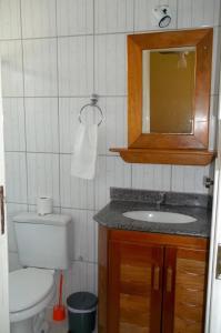 uma casa de banho com um WC, um lavatório e um espelho. em Porto Verano Residence em Porto Seguro