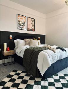 a bedroom with a bed with a black and white comforter at Coventry Lovely House, Sleeps 4, by Empower Homes in Coventry