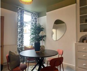a dining room with a table and chairs and a mirror at Coventry Lovely House, Sleeps 4, by Empower Homes in Coventry